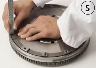 Press gently on the opposite side of the secondary flywheel